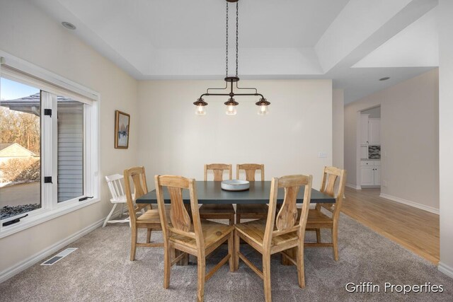 7834 Strawberry Ln NE, Belmont, MI 49306 - dining space with light wood-style floors, visible vents, a raised ceiling, and baseboards
