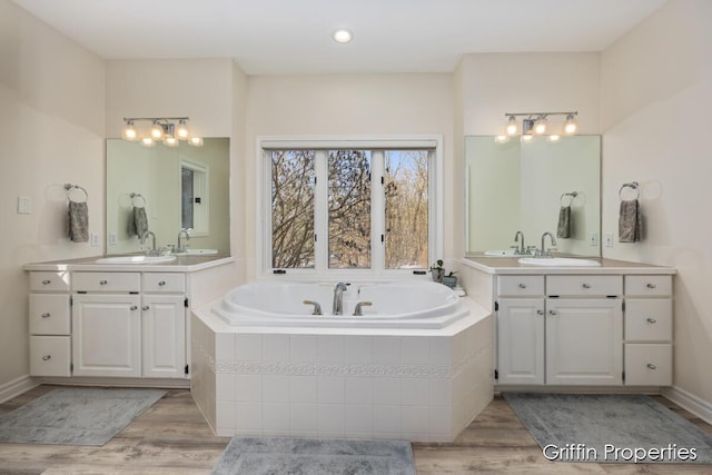 7834 Strawberry Ln NE, Belmont, MI 49306 - bathroom with a sink, a garden tub, and wood finished floors
