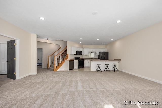 7834 Strawberry Ln NE, Belmont, MI 49306 - unfurnished living room featuring recessed lighting, baseboards, light carpet, and stairs