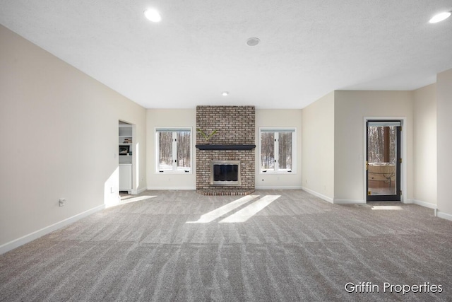 7834 Strawberry Ln NE, Belmont, MI 49306 - unfurnished living room with a wealth of natural light, a brick fireplace, baseboards, and carpet floors