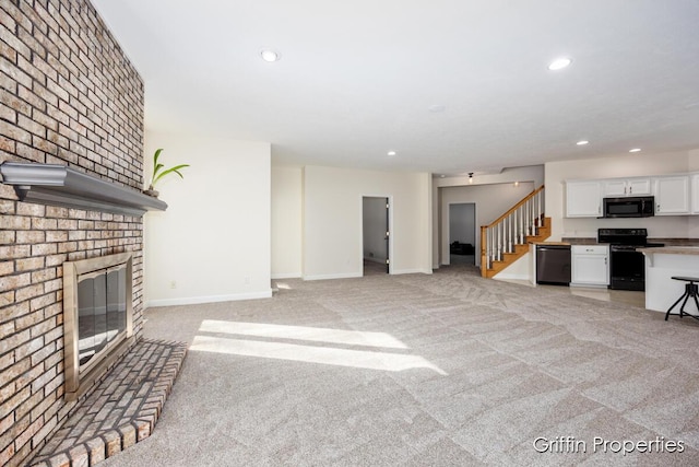 7834 Strawberry Ln NE, Belmont, MI 49306 - unfurnished living room featuring recessed lighting, light colored carpet, a fireplace, and stairs