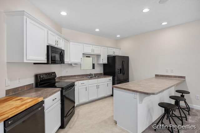 7834 Strawberry Ln NE, Belmont, MI 49306 - kitchen with white cabinetry, black appliances, a peninsula, and a sink