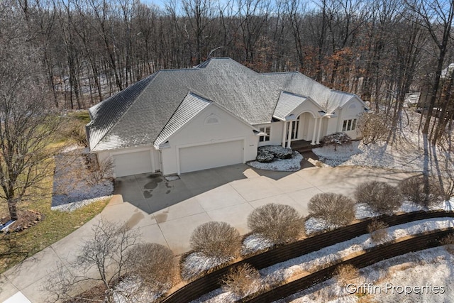 7834 Strawberry Ln NE, Belmont, MI 49306 - view of front of house featuring stucco siding, an attached garage, a shingled roof, and driveway
