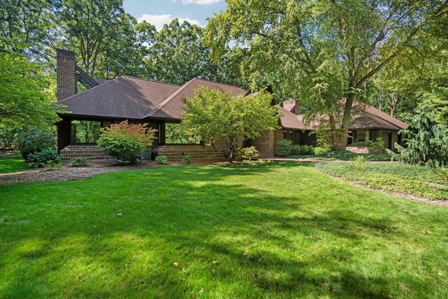 4923 Hickory Hill Rd, Ann Arbor, MI 48105 - view of front of property with a shingled roof, a chimney, and a front yard