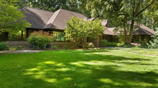 4923 Hickory Hill Rd, Ann Arbor, MI 48105 - view of front of home with a chimney, brick siding, and a front yard