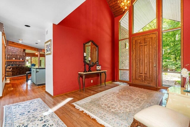 4923 Hickory Hill Rd, Ann Arbor, MI 48105 - foyer entrance featuring a notable chandelier, hardwood / wood-style flooring, vaulted ceiling, and visible vents