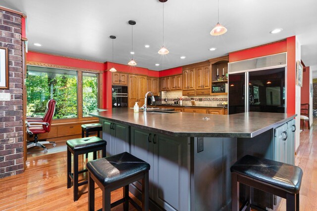 4923 Hickory Hill Rd, Ann Arbor, MI 48105 - kitchen with a sink, refrigerator, black microwave, brown cabinetry, and dark countertops