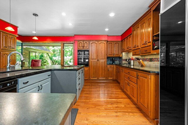 4923 Hickory Hill Rd, Ann Arbor, MI 48105 - kitchen featuring backsplash, a sink, black fridge, light wood-style flooring, and dark countertops