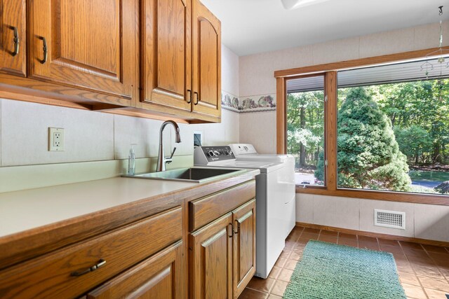4923 Hickory Hill Rd, Ann Arbor, MI 48105 - clothes washing area featuring light tile patterned floors, a sink, visible vents, cabinet space, and washing machine and dryer