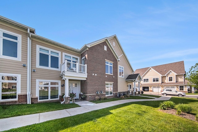 616 Boardwalk Ln, Dexter, MI 48130 - multi unit property featuring a front lawn, a balcony, and brick siding