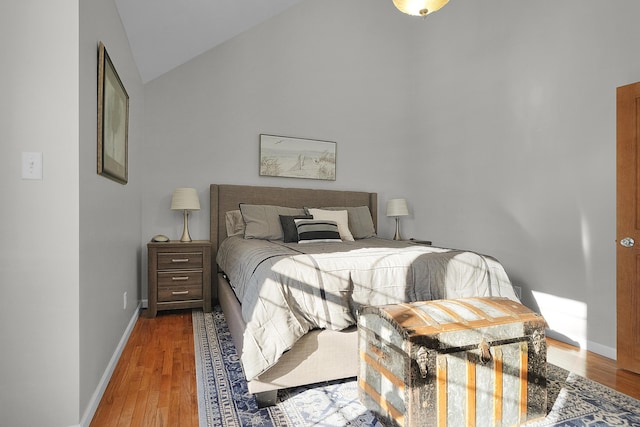 bedroom featuring vaulted ceiling, wood finished floors, and baseboards
