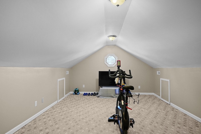 workout room featuring baseboards, carpet, and vaulted ceiling