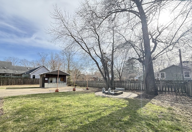 view of yard with a patio, an outdoor structure, and a fenced backyard