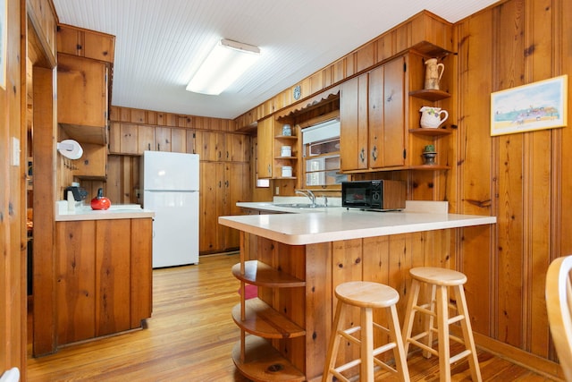 36.5 Lake Shore Dr, South Haven, MI 49090 - kitchen with open shelves, brown cabinetry, a peninsula, and freestanding refrigerator