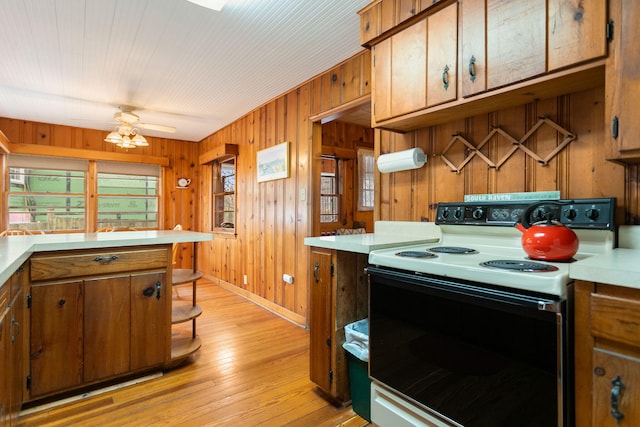 36.5 Lake Shore Dr, South Haven, MI 49090 - kitchen featuring light countertops, baseboards, electric stove, light wood-style floors, and brown cabinetry