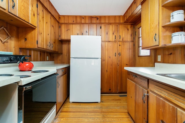 36.5 Lake Shore Dr, South Haven, MI 49090 - kitchen with light countertops, open shelves, range with electric stovetop, freestanding refrigerator, and brown cabinets