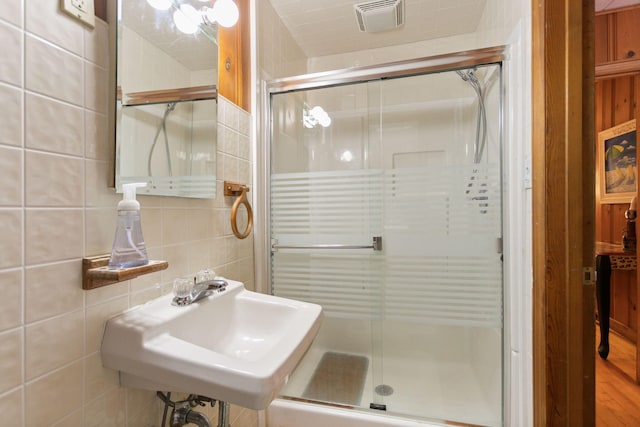 36.5 Lake Shore Dr, South Haven, MI 49090 - full bath featuring tile walls, visible vents, a shower stall, tasteful backsplash, and a sink