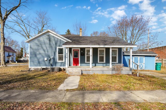 816 7th St, Three Rivers, MI 49093 - view of front of home with a front yard, covered porch, a chimney, an outdoor structure, and a storage unit