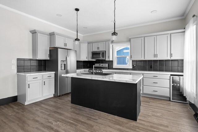 816 7th St, Three Rivers, MI 49093 - kitchen with beverage cooler, ornamental molding, wood finished floors, stainless steel appliances, and a sink