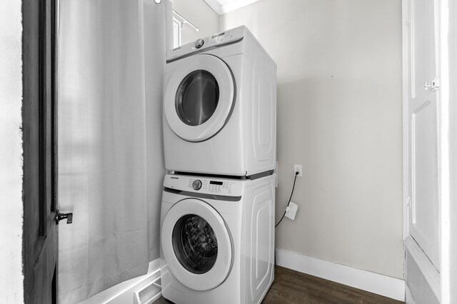 816 7th St, Three Rivers, MI 49093 - washroom featuring baseboards, dark wood-style flooring, laundry area, and stacked washing maching and dryer