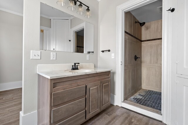 816 7th St, Three Rivers, MI 49093 - bathroom with visible vents, tiled shower, wood finished floors, and vanity