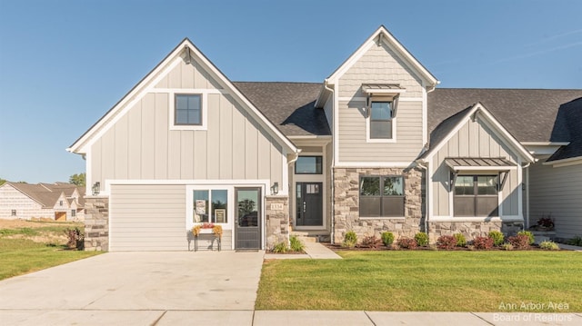 1303 Gallery Pointe Dr, Saline, MI 48176 - view of front of property with board and batten siding, a shingled roof, concrete driveway, a front yard, and stone siding