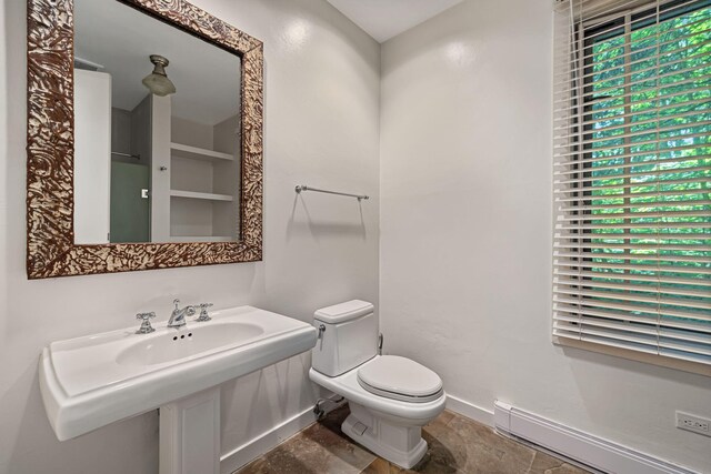 5716 E 1000 N, La Porte, IN 46350 - bathroom with stone finish flooring, baseboards, a baseboard radiator, toilet, and a sink