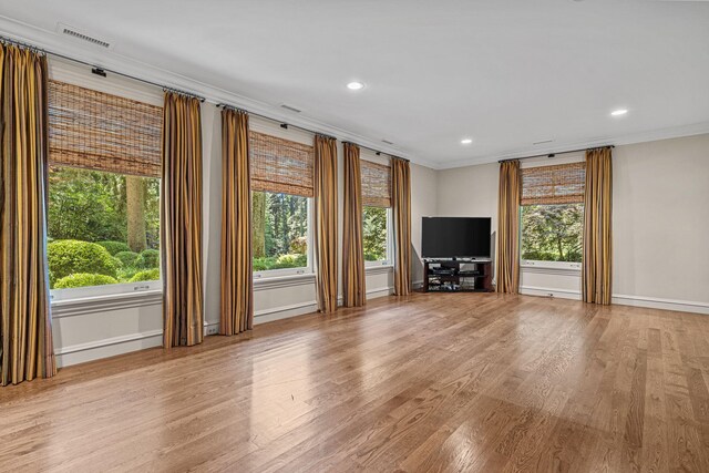 5716 E 1000 N, La Porte, IN 46350 - unfurnished living room with visible vents, crown molding, baseboards, wood finished floors, and recessed lighting