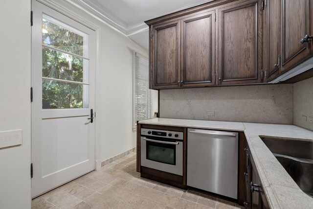 5716 E 1000 N, La Porte, IN 46350 - kitchen with ornamental molding, stainless steel appliances, dark brown cabinetry, a sink, and backsplash
