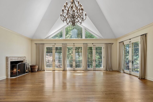 5716 E 1000 N, La Porte, IN 46350 - unfurnished living room featuring a premium fireplace, french doors, an inviting chandelier, high vaulted ceiling, and wood finished floors