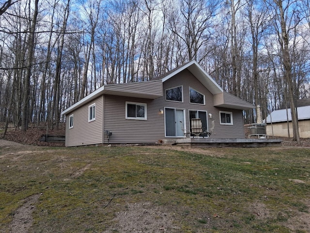 view of front of house with a wooden deck and a front lawn