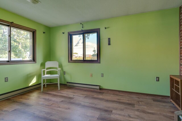 5844 S Scottdale Rd, Berrien Springs, MI 49103 - unfurnished room with baseboards, wood finished floors, and a baseboard heating unit
