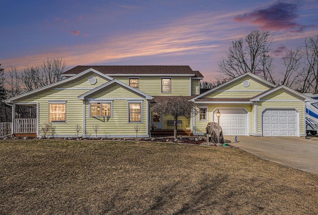 view of front of property featuring an attached garage, a front lawn, and concrete driveway