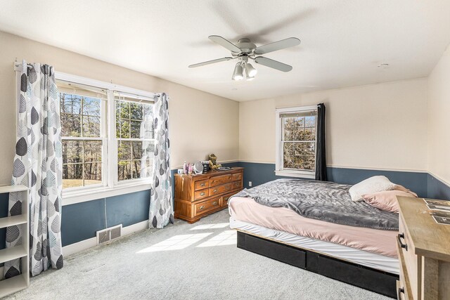 carpeted bedroom with visible vents and a ceiling fan