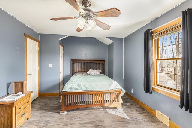 bedroom featuring baseboards, light wood-style flooring, visible vents, and ceiling fan