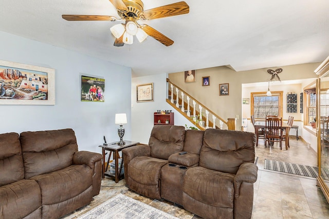 living room with stairway and a ceiling fan