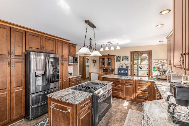 kitchen with brown cabinets, light stone counters, a peninsula, and stainless steel appliances