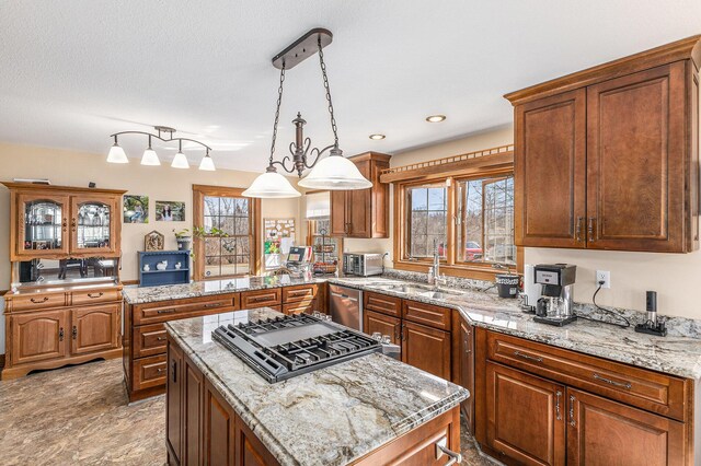 kitchen featuring a center island, a healthy amount of sunlight, a sink, and dishwasher