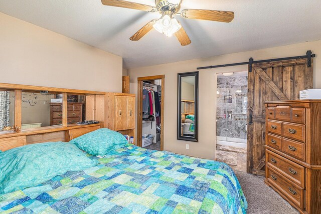 bedroom featuring a closet, a barn door, a spacious closet, a textured ceiling, and carpet