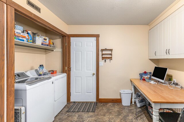 washroom with baseboards, a textured ceiling, washing machine and clothes dryer, visible vents, and cabinet space