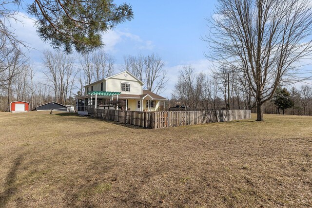 view of yard featuring a pergola, an outdoor structure, fence, and a garage