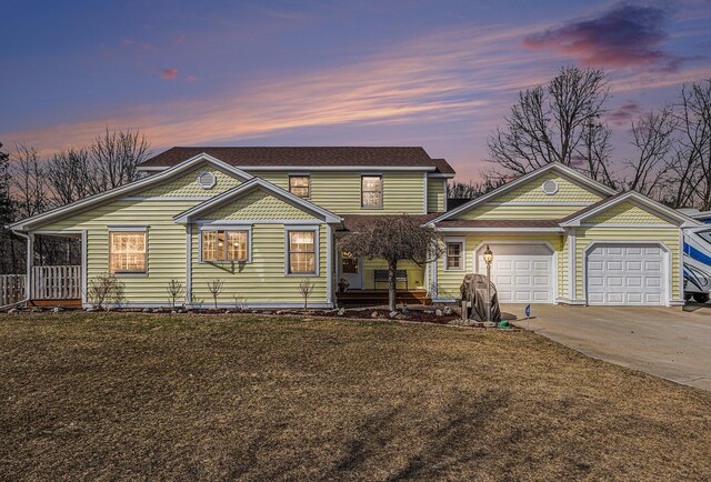 view of front of home featuring driveway, an attached garage, and a yard