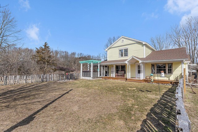 back of house with fence, a pergola, roof with shingles, covered porch, and a yard