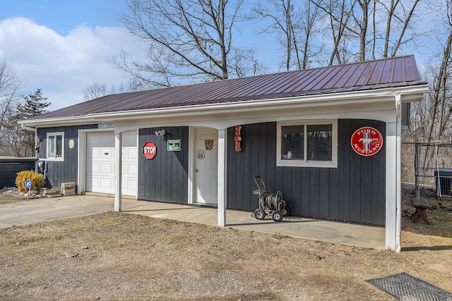 view of front facade with driveway and metal roof