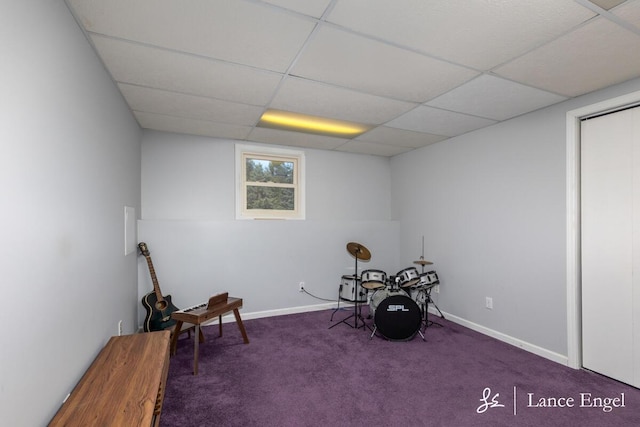 misc room featuring carpet flooring, baseboards, and a drop ceiling