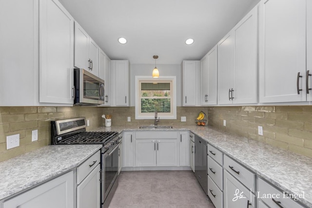 kitchen with a sink, stainless steel appliances, and white cabinetry