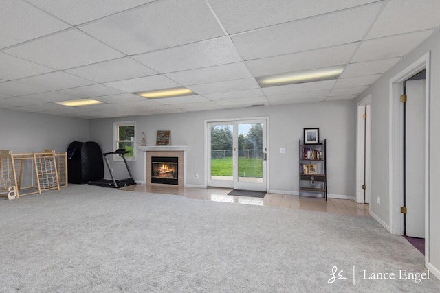 interior space with baseboards, a fireplace, and a drop ceiling