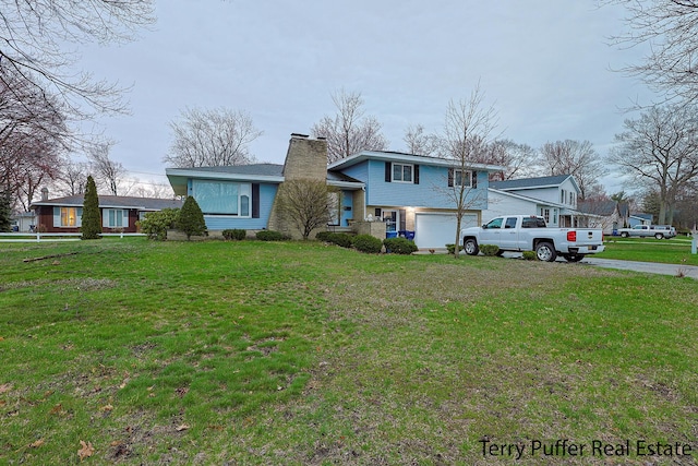 view of front facade featuring a chimney, an attached garage, driveway, and a front lawn