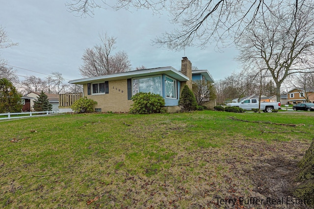 view of front of property featuring fence, a front lawn, and a chimney
