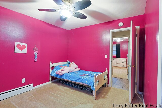 bedroom with a baseboard heating unit, a ceiling fan, and carpet flooring